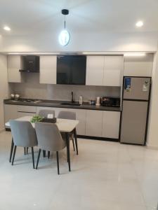 a kitchen with a table and chairs and a refrigerator at شقق الياسمين in Medina