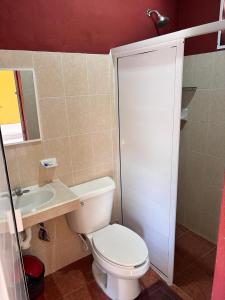 a bathroom with a white toilet and a sink at Posada el Sol in El Cuyo