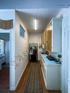 a kitchen with white cabinets and a blue counter top at Ruby Bay Beach Sleepout - 30 mins from Abel Tasman in Mapua