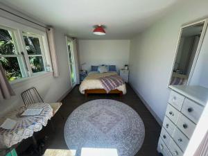 a small bedroom with a bed and a dresser at Ruby Bay Beach Sleepout - 30 mins from Abel Tasman in Mapua