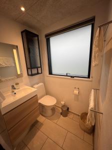 a bathroom with a toilet and a sink and a window at House with a lovely location in Børkop