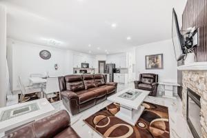 a living room with leather furniture and a fireplace at Cozy Vacation Home in Calgary