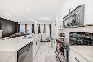 a kitchen with white counter tops and a stove top oven at Cozy Vacation Home in Calgary