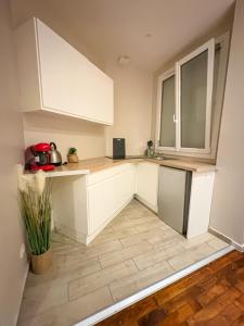 a kitchen with white cabinets and a tile floor at Centre ville - Houilles in Houilles
