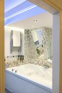 a bathroom with a tub and a large mirror at 90A Tower Road in Newquay