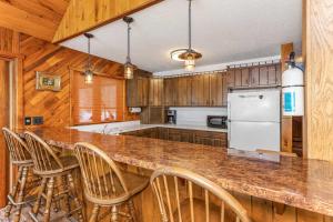 a kitchen with a counter with chairs and a refrigerator at Grace Place in Watersmeet