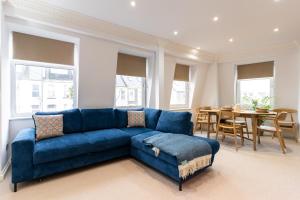 a living room with a blue couch and a table at 90A Tower Road in Newquay