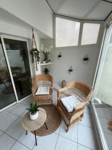 a porch with two wicker chairs and a table at Le Liseo - Terrasse, véranda au cœur du centre ville in Niort