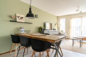 a kitchen and dining room with a wooden table and chairs at Appartement Senang, Resort Amelander Kaap in Hollum