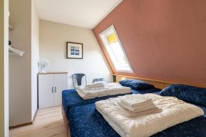 a bedroom with two beds and a window at Appartement Senang, Resort Amelander Kaap in Hollum +66 photos