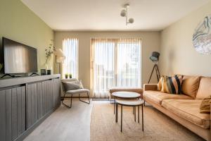 a living room with a couch and a tv at Appartement Senang, Resort Amelander Kaap in Hollum