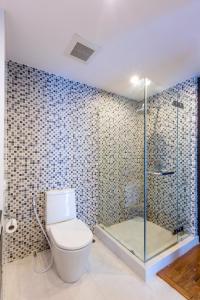 a bathroom with a toilet and a glass shower at Baan Poolom Beachfront Condominium in Hua Hin