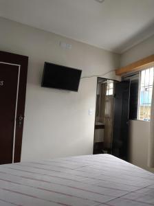 a bedroom with a bed and a flat screen tv at Hotel Flor da Vila Mariana in São Paulo