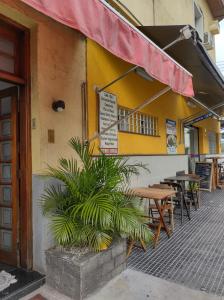 a restaurant with tables and chairs and a red awning at Hotel Flor da Vila Mariana in São Paulo