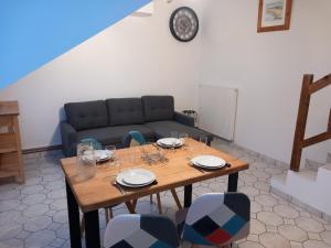 a table with chairs and a couch in a room at Gite Le Savart in Chartèves