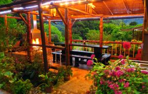 a wooden pergola with a bench and some flowers at EcoLodge La Pluma in Salento