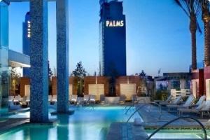 a large swimming pool with chairs and a building at Palms Place in Las Vegas