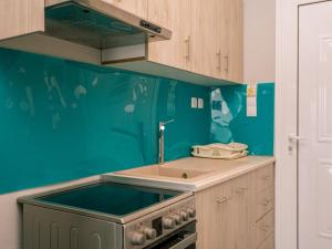 a blue kitchen with a sink and a stove at Bay View Suites & Apartments in Marathias