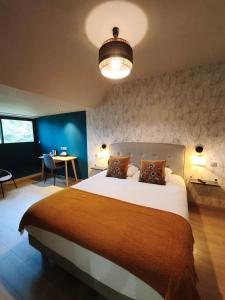 a bedroom with a large bed and a blue wall at Hôtel Restaurant Logis La Méridienne in Anglards-de-Saint-Flour