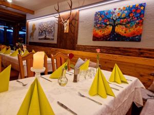 a dining room with a table with yellow napkins at Berggasthof Karlbauer in Lendorf