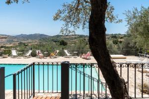 a view of a pool with chairs and a tree at Villa Roba degli Ulivi in Agrigento