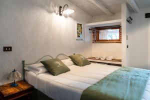 a bedroom with a bed with two green pillows at Villa Roba degli Ulivi in Agrigento