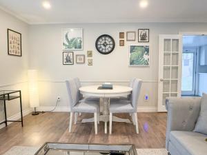 a living room with a table and chairs and a clock at Addison House License# 004-2025 in Niagara-on-the-Lake +31 photos