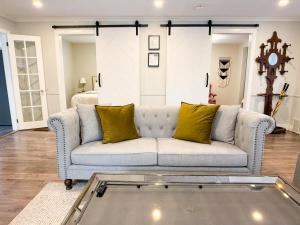 a living room with a couch with yellow pillows at Addison House License# 004-2025 in Niagara-on-the-Lake