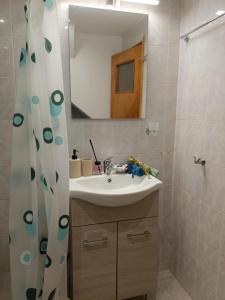 a bathroom with a sink and a mirror and a shower at Aπανεμα Ανδ συγγρου 34 in Galaxidi