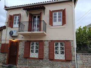 a white house with wooden shutters and a balcony at Aπανεμα Ανδ συγγρου 34 in Galaxidi