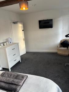 a bedroom with a bed and a tv on the wall at The White Hart Hotel in Shefford