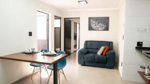 a living room with a table and a blue chair at Jahu Center Casas Un 4 in Jaú