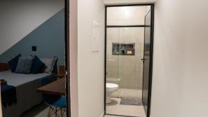 a bathroom with a shower and a toilet and a bed at Jahu Center Casas Un 4 in Jaú +70 photos