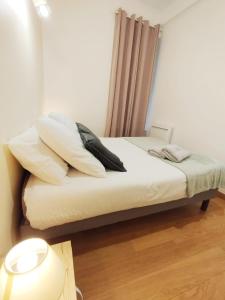 a bed with white sheets and pillows in a room at Les Gîtes d'Altaïr - La Petite Ourse in Tarascon-sur-Ariège
