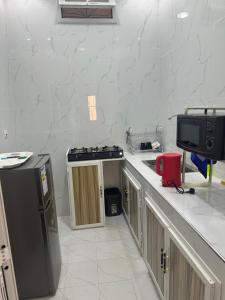 a kitchen with a black refrigerator and a tv at Omega Apparts A2 in Rufisque