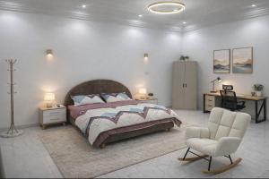 a bedroom with a bed and a chair and a desk at Omega Apparts A2 in Rufisque