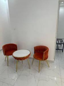 two chairs and a table in a room at Omega Apparts A2 in Rufisque