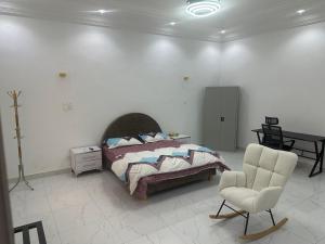 a bedroom with a bed and a chair at Omega Apparts A2 in Rufisque