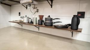 a kitchen counter with pots and pans on a shelf at Jahu Center Casas Un 4 in Jaú