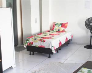 a bedroom with a bed with a flowered comforter at São Francisco Aparts in Salvador
