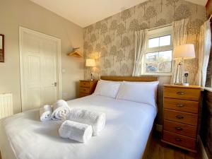 a bedroom with a white bed with towels on it at Brown Snout in Ledbury