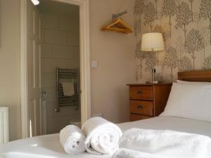 a bedroom with towels on a bed with a mirror at Brown Snout in Ledbury +6 photos