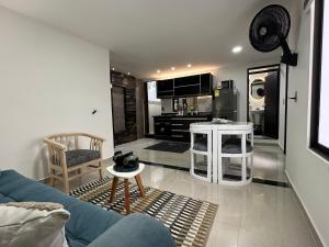 a living room with a blue couch and a kitchen at 202 Apartaestudio Edificio Natura 54, cercano Centro Comerciales in Ibagué
