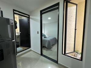 a room with a bedroom with a bed and a mirror at 202 Apartaestudio Edificio Natura 54, cercano Centro Comerciales in Ibagué