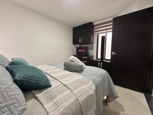 a bedroom with a bed with two pillows on it at 202 Apartaestudio Edificio Natura 54, cercano Centro Comerciales in Ibagué +10 photos