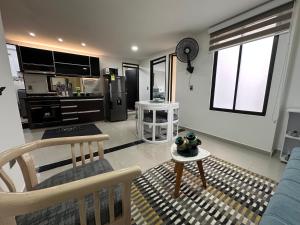 a living room with a blue couch and a kitchen at 202 Apartaestudio Edificio Natura 54, cercano Centro Comerciales in Ibagué