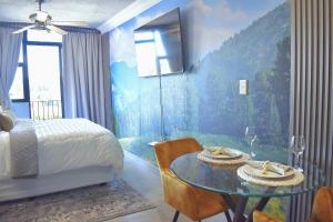 a bedroom with a bed and a table with chairs at Lynwood Circa 209 in Pretoria