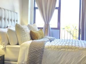 a bedroom with a white bed with a window at Lynwood Circa 209 in Pretoria