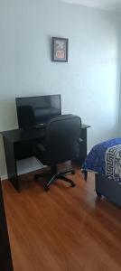 a desk with a television and a chair in a room at Accomodation in Cape Town in Goodwood