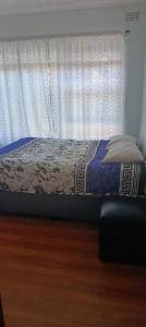 a bed in a room with a window at Accomodation in Cape Town in Goodwood